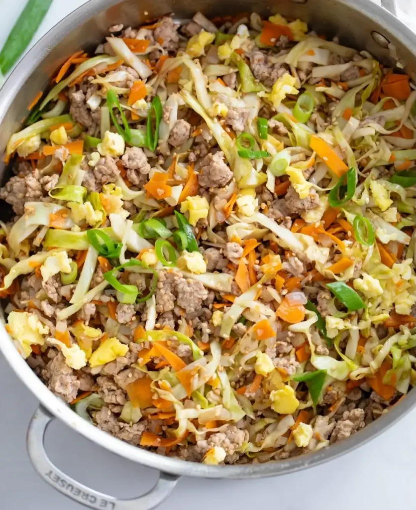 Egg Roll in a Bowl 2 Egg roll in a bowl with ground chicken, cabbage, and carrots in a skillet