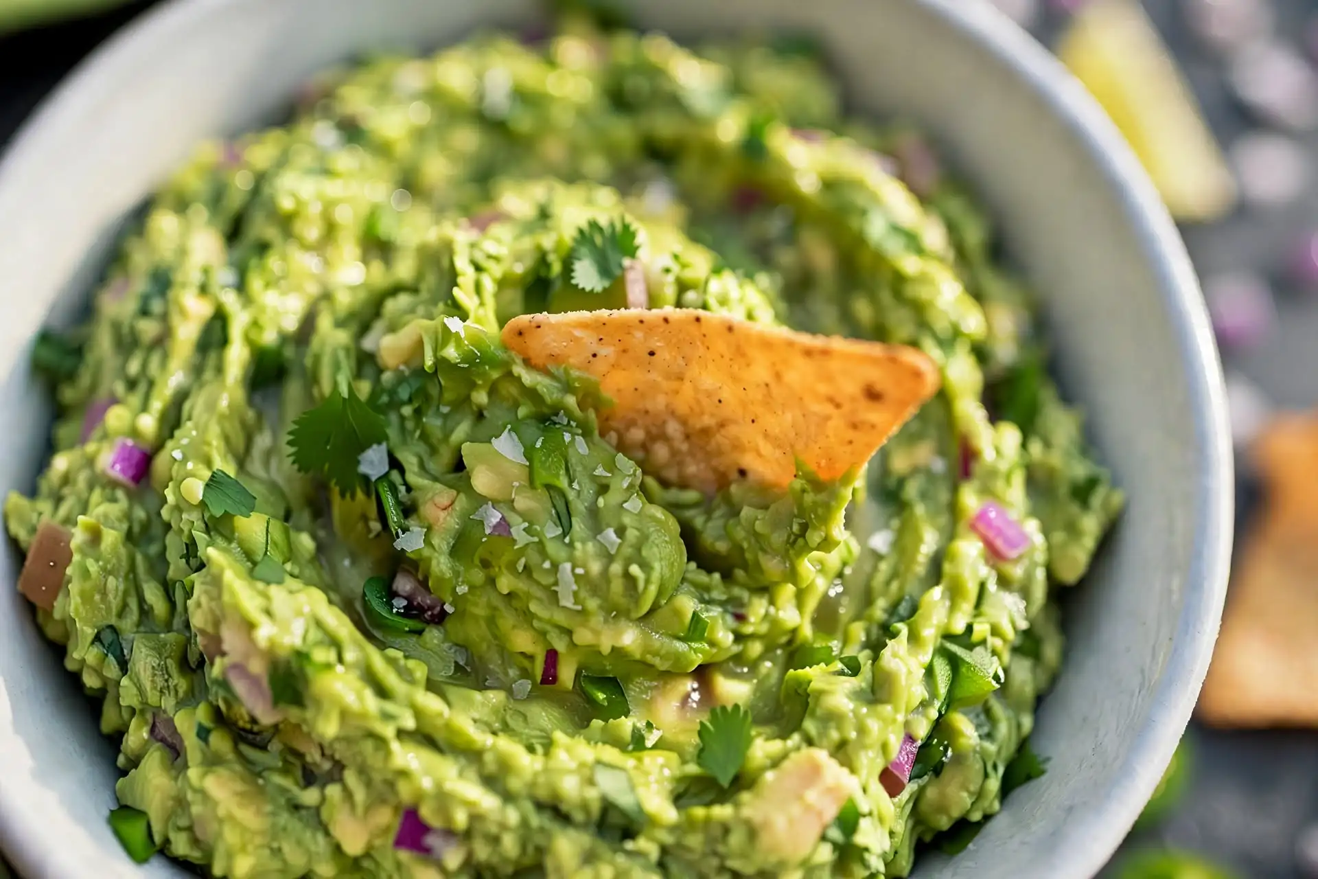 Guacamole 5 Fresh guacamole in a molcajete bowl with lime wedges and tortilla chips