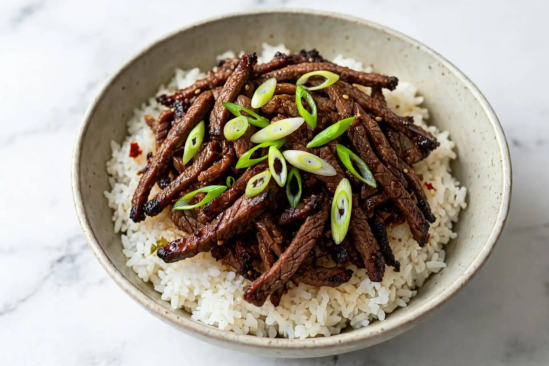 Mongolian Beef 5 Mongolian beef with green onion over rice, overhead shot