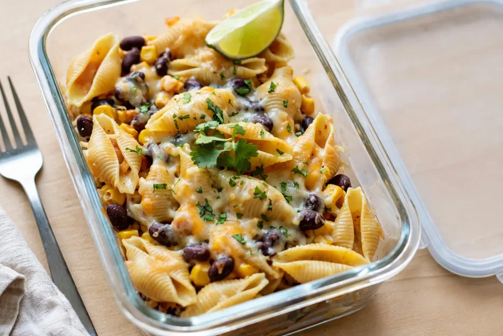 Taco Pasta 4 Leftover taco pasta in a glass meal prep container with lime wedge, packed for next day lunch